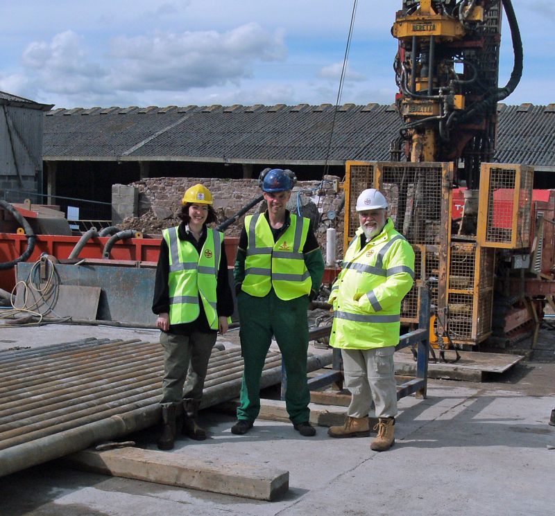 Carys Bennett (Uni. of Leicester), Alistair Birkett (landowner) and Dave Millward (BGS) standing in front of the rig.