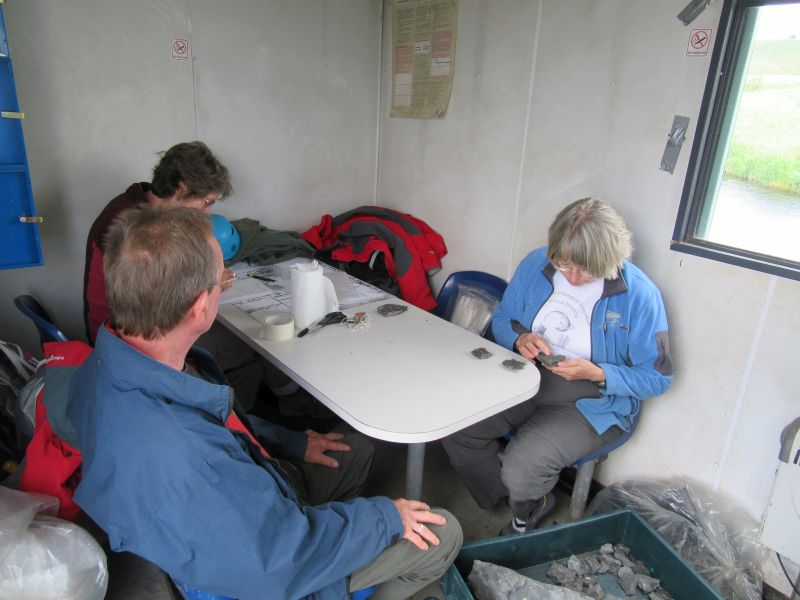 When the weather was unfavourable, we sat in the hut packing and labeling specimens.  Here, Jenny Clack identifies the bones, Rob Clack packs them in acid-free paper and foam or bubble film, and Janet Sherwin records the details.